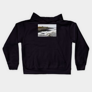 Dunstanburgh castle with rough waves battering the coast in Northumberland, UK Kids Hoodie